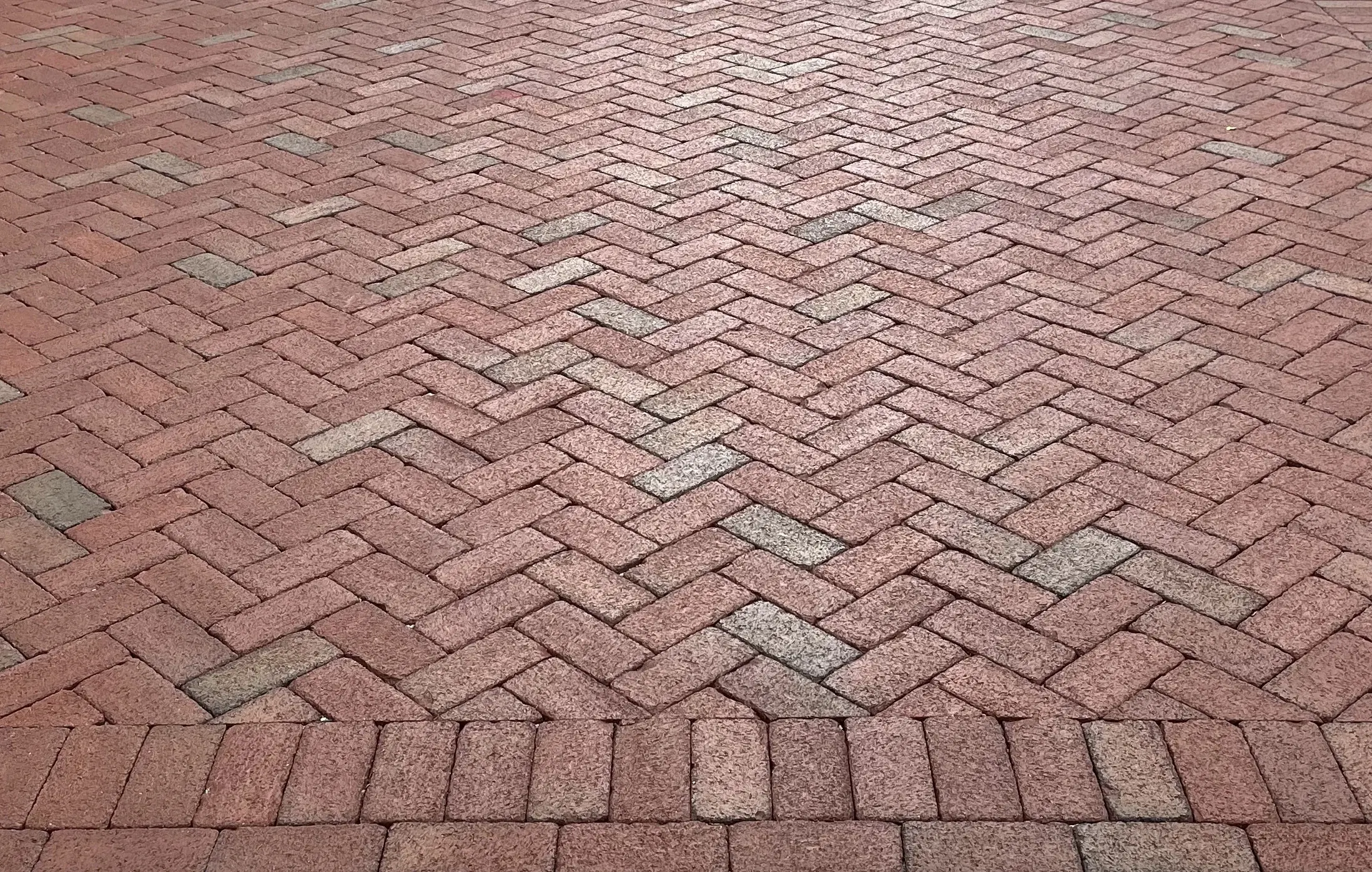 Traditional clay brick paving laid in a herringbone pattern