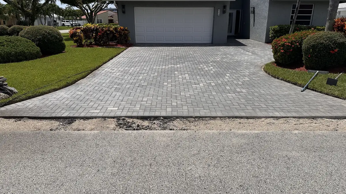 Loose asphalt removed from the paver driveway edge during repair