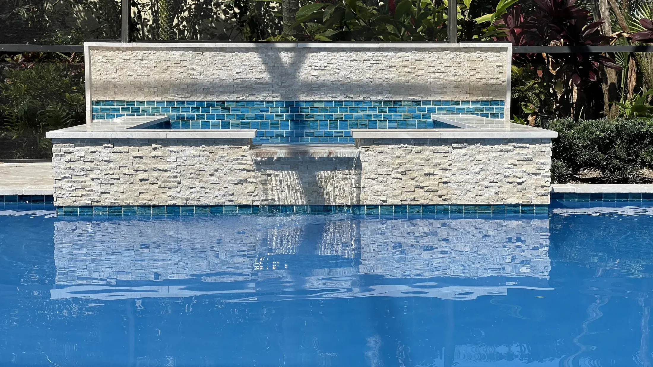 Remodeled pool fountain finished with ledgestone and blue waterline tile
