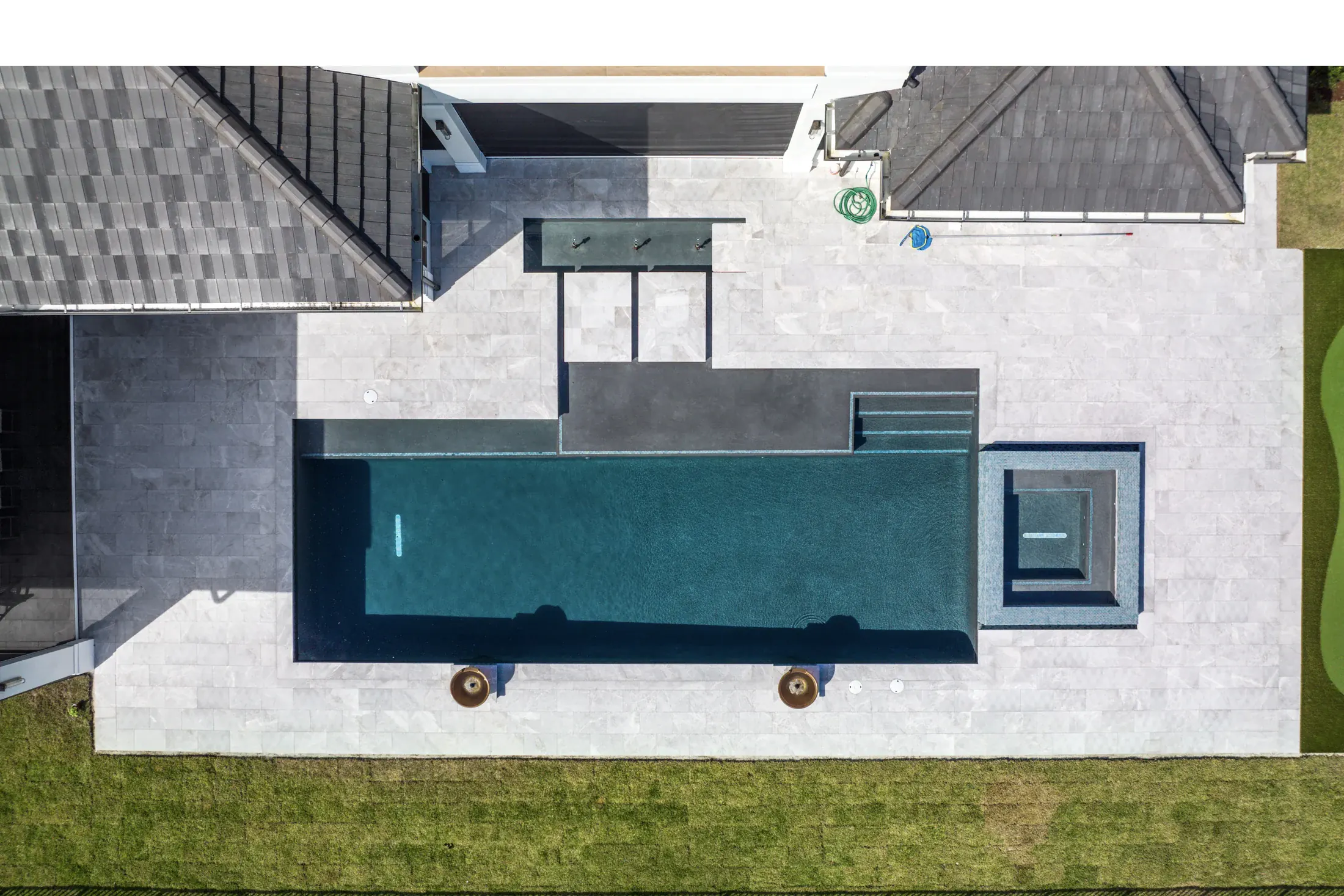 Aerial view of a completed light natural stone pool deck at a South Florida home