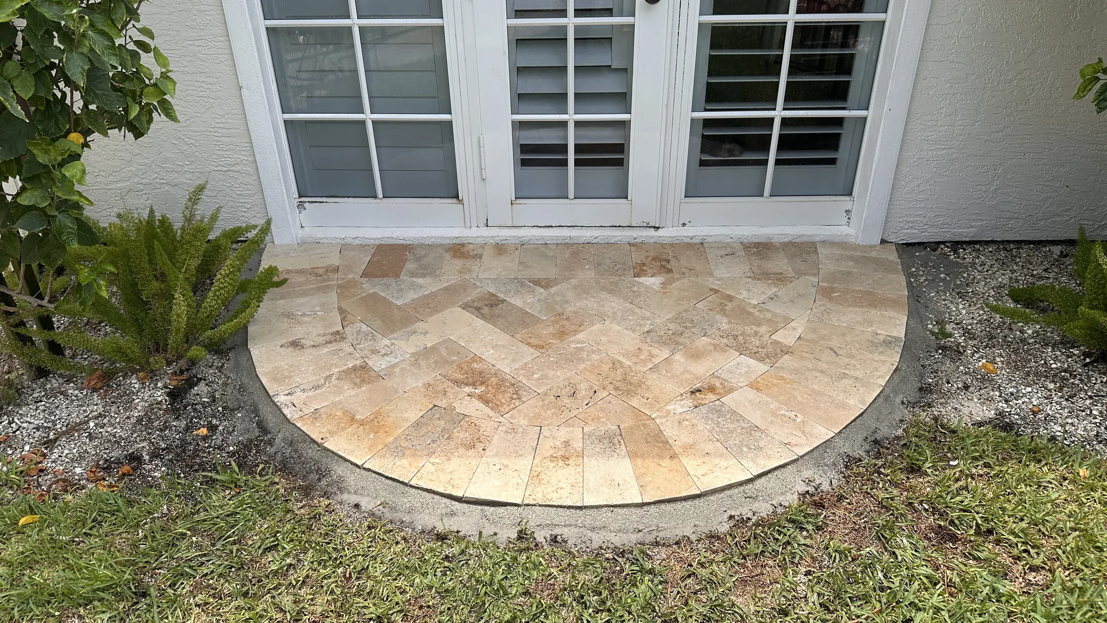 Small curved paver addition installed beside a home